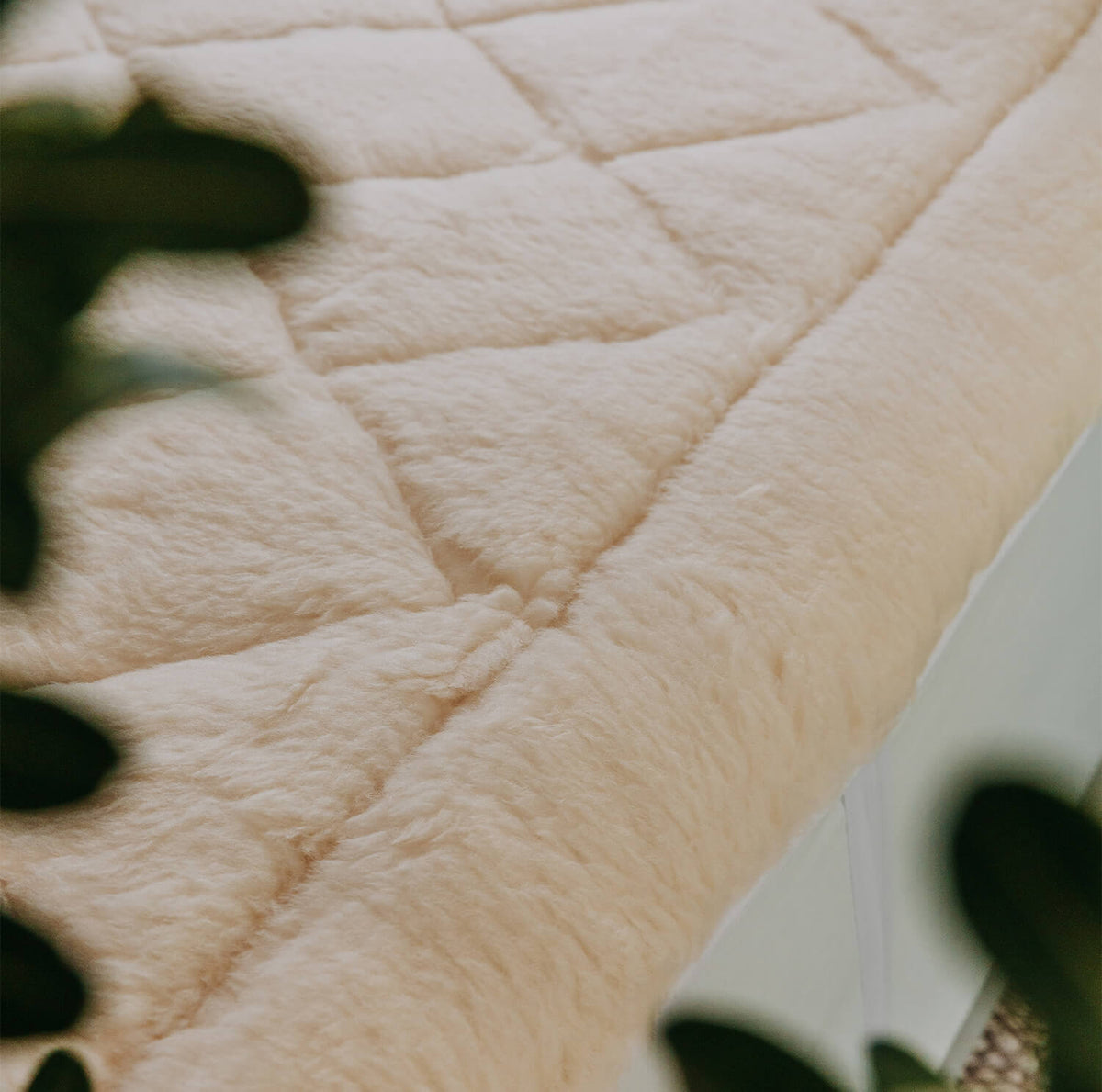 Close-up of a cream Australian wool mattress topper showing the diamond quilting